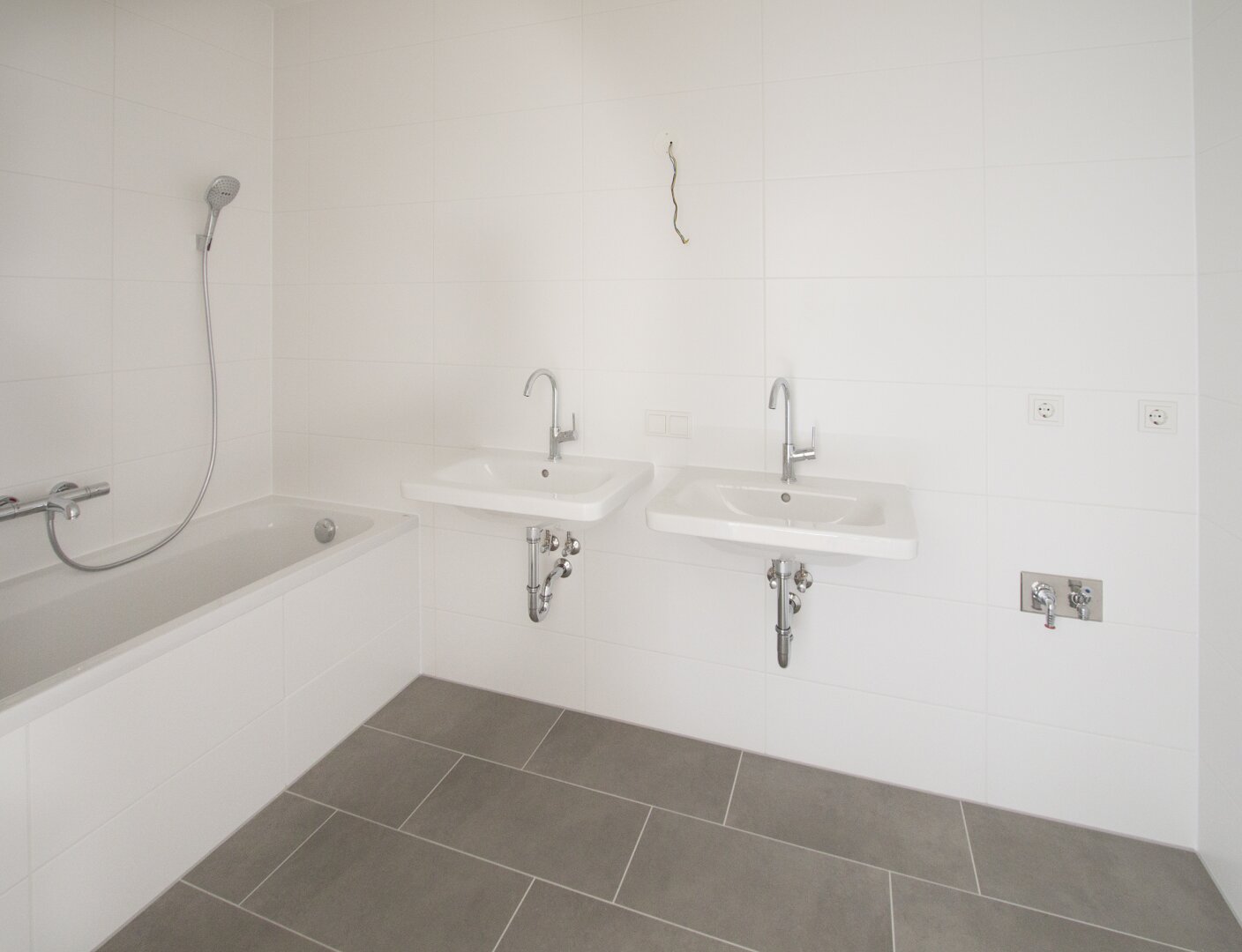 Badezimmer mit 2 Waschbecken, Badewannne und Waschmaschinen Anschluss
