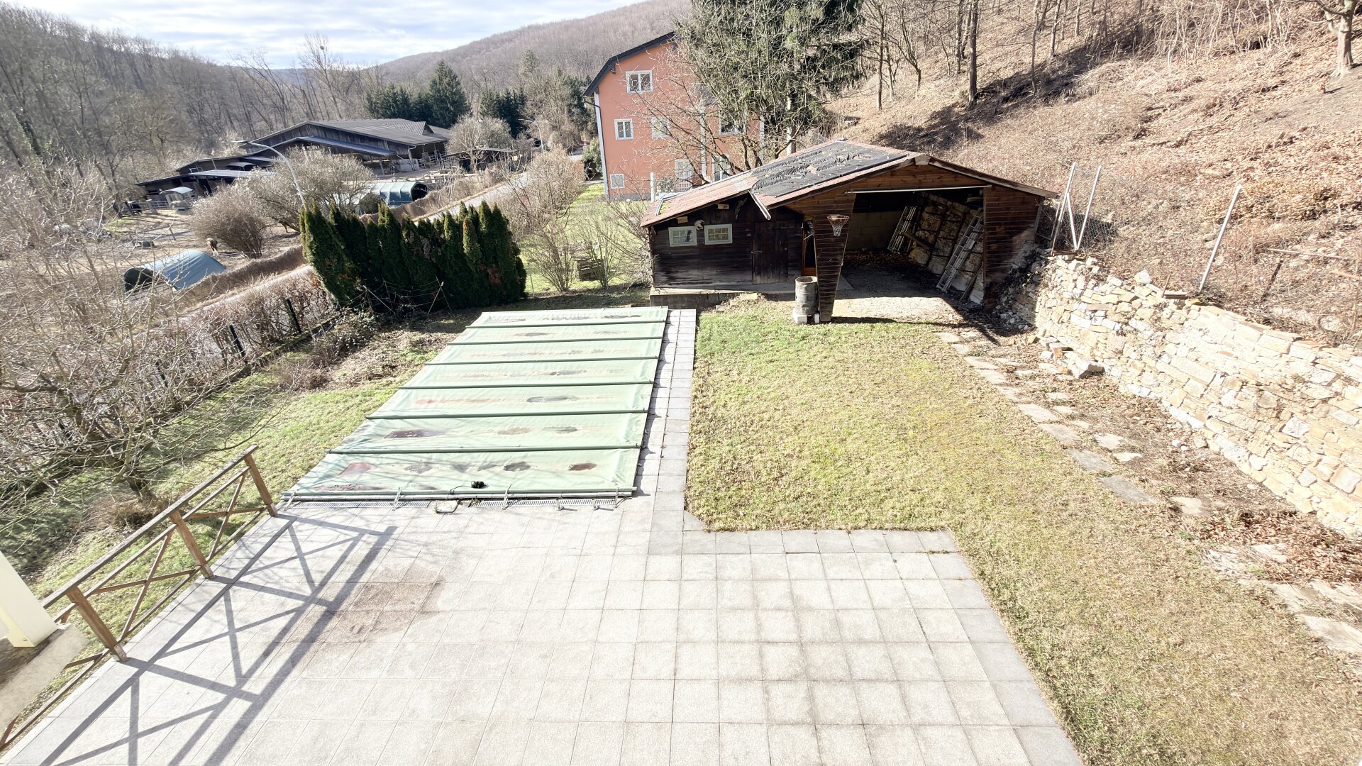 Blick vom 1. Stock auf Terrasse und abgedeckten Pool