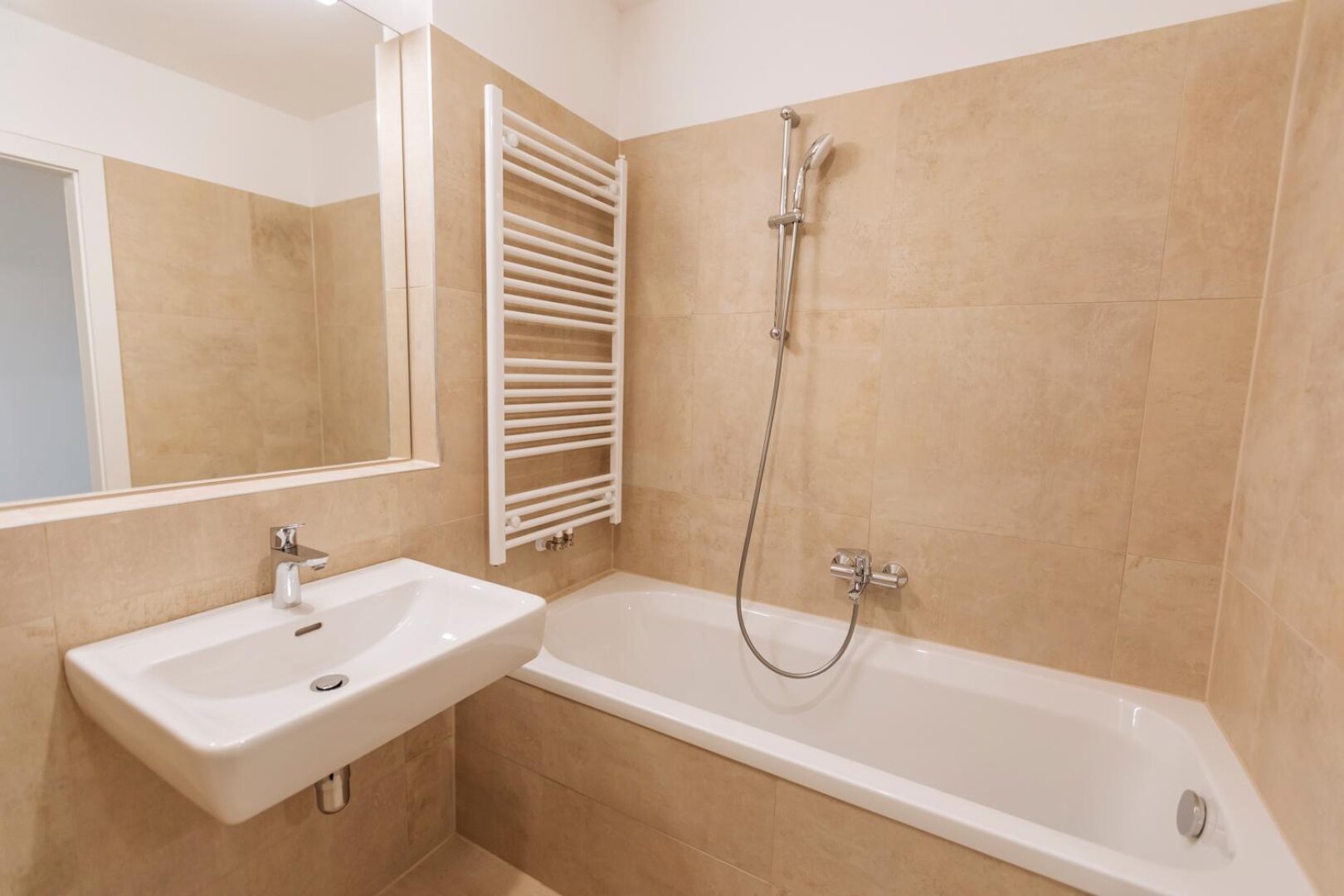geschmackvolles Badezimmer mit Badewanne und Sprossenheizkörper