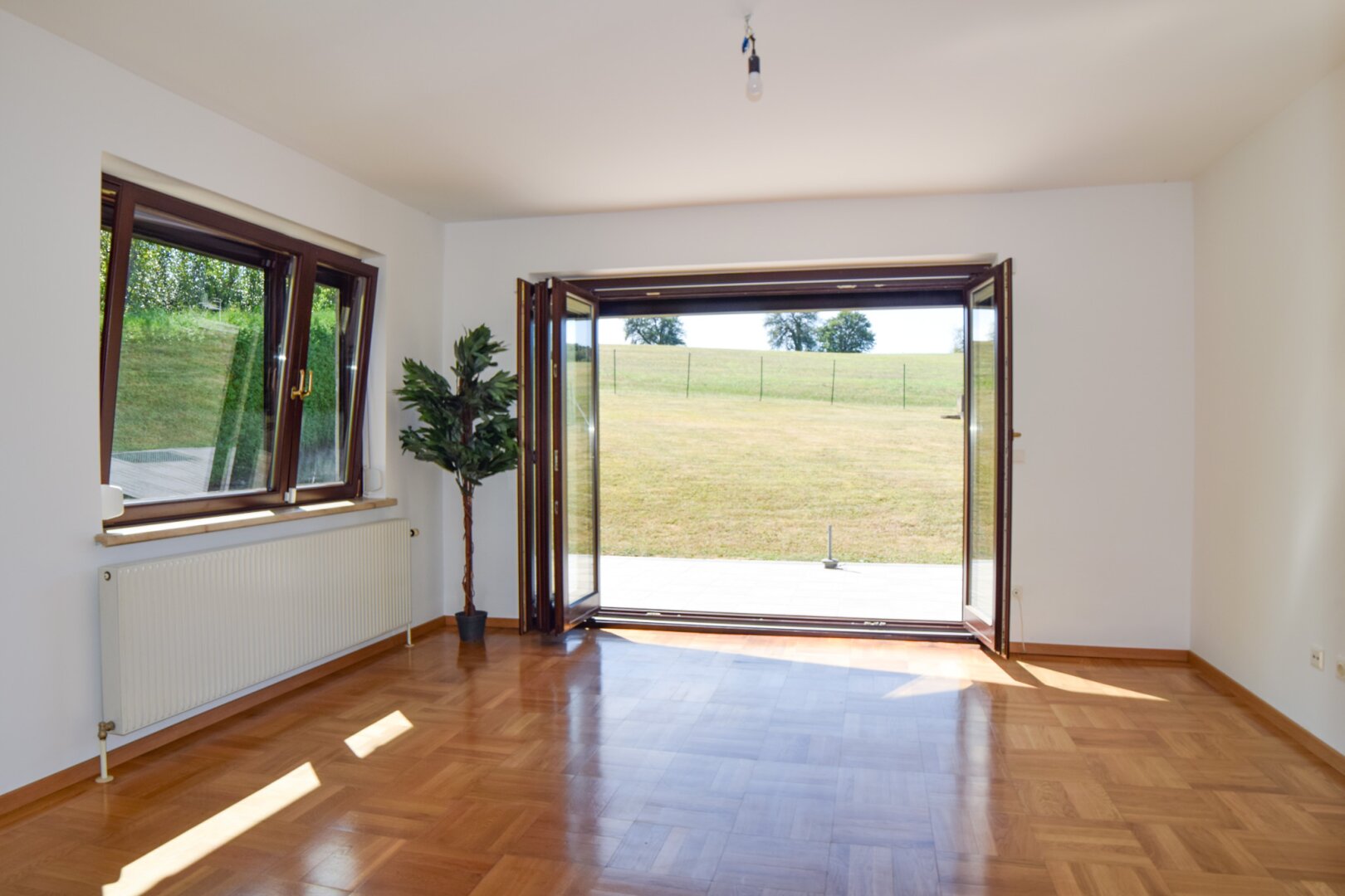 Wohn- und Esszimmer mit Ausgang zur sonnigen West-Terrasse und in den großzügigen Garten